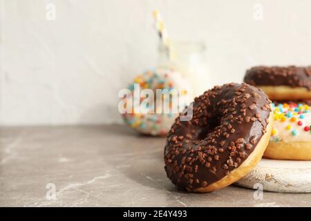 Jar of milk and tasty donuts on gray table Stock Photo