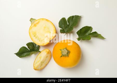 Round zucchini with fresh leaves on a white background, a bright botanical vegetable shot for menus and blogs Stock Photo