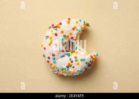Tasty bitten donut on beige background, top view Stock Photo