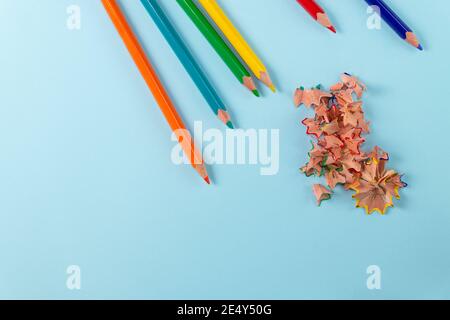 Sharpened colored pencils and pencil shavings on pastel blue color. Rainbow or LGBT pencils. Top view Stock Photo