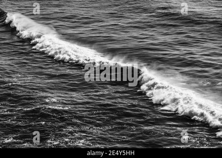 safire colored waves of the sea with its surf approaching the beach seen from above Stock Photo