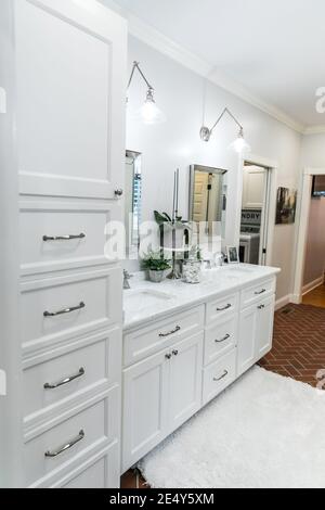 Large white renovated master bathroom with red brick floors Stock Photo