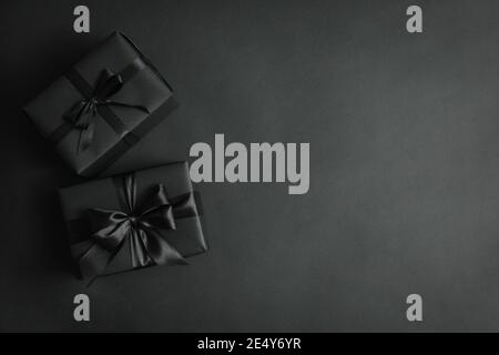 Black background with gift boxes and black bows, luxury black presents for Black Friday sale and gift concept Stock Photo