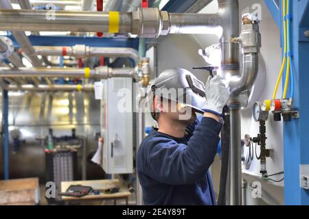 welder works in steel construction and repairs an industrial plant Stock Photo