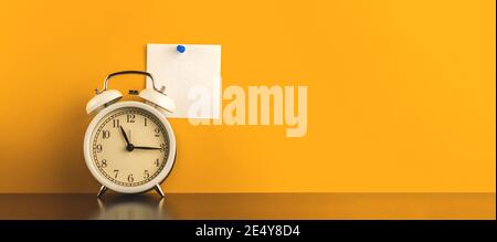 Minimal workspace conceptual creative photo with pinned blank notepad paper, banner with alar clock on a table, yellow background photo Stock Photo