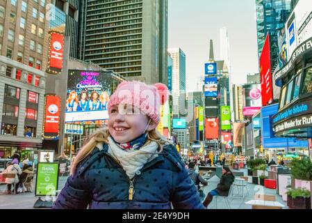 New York, NY USA December 6 2020: Young Girl smiling and looking up in New York City's Times Square Stock Photo
