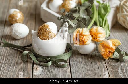 Festive composition for the Easter holiday with fresh flowers and eggs. Easter decor concept. Stock Photo