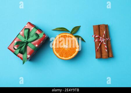 Mandarin, cinnamon and gift box on blue background Stock Photo