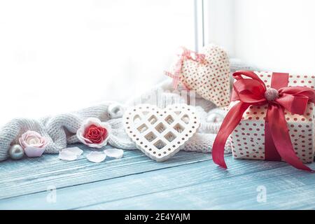 Beautifully wrapped valentine's day gift and cute holiday decor details on a wooden surface. Stock Photo