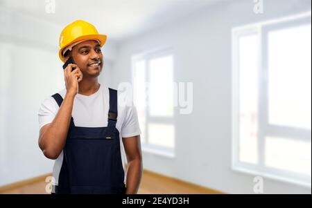 indian builder in helmet calling on smartphone Stock Photo