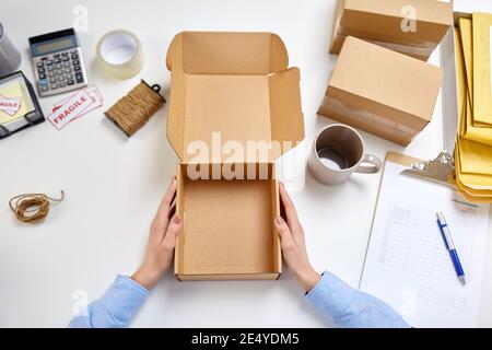 hands with empty parcel box and mug at post office Stock Photo