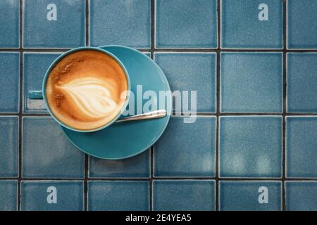 Coffe with latte art on top in blue cup, top view Stock Photo