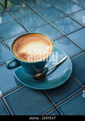 Coffe with latte art on top in blue cup closeup Stock Photo
