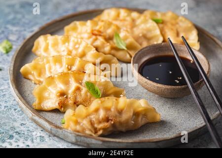 Asian dumplings with soy sauce, sesame seeds and microgreens. Traditional chinese dim sum dumplings.