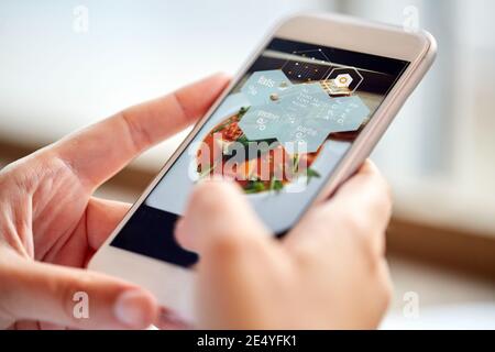 hands with phone and food nutritional value chart Stock Photo