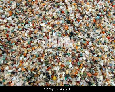 A pile full of small agate stones makes a pretty colorful background or backdrop with lots of color, shapes and sizes. Slight bokeh effect. Stock Photo