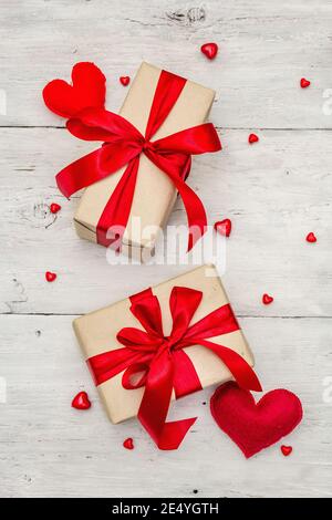 Valentine greeting card background with gift boxes, red ribbons and assorted hearts. Old white wooden boards background. Wedding or Birthday concept, Stock Photo