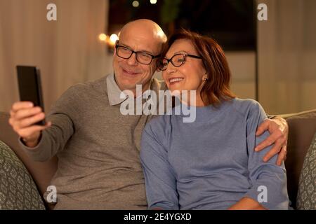 old couple taking selfie with smartphone at home Stock Photo