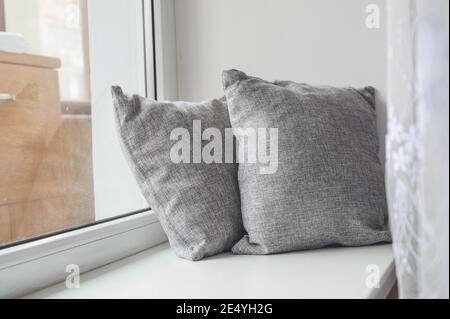 Soft cushions on white sill. Cozy pillows. Stock Photo