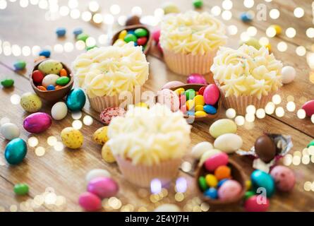 cupcakes with easter eggs and candies on table Stock Photo