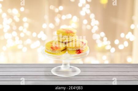 yellow macaroons on glass confectionery stand Stock Photo
