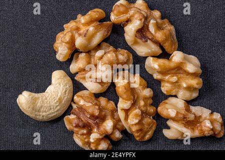 Kernels of cashews and walnuts lie on a dark cloth background Stock Photo