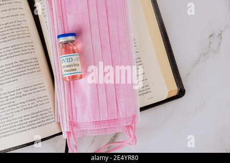 22 JANUARY 21 New York US 2021: Opened the Holy Bible close up prayer time with Negative attitude of the church to vaccination and covid-19 vaccine bottle Stock Photo