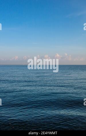 Blue sea with waves and sky with small airy clouds Stock Photo