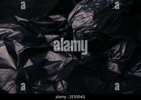 Crumpled dark black paper texture abstract background Stock Photo