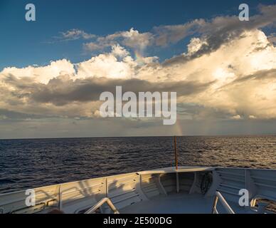 Rainbow over the Pacific Ocean as seen from the bow of the True North Stock Photo