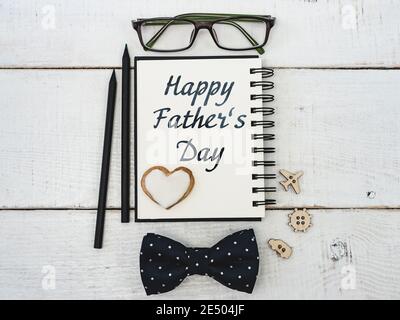 Notebook for congratulating your father, glasses, pencil, pen on a beautiful, white table. Top view of a close-up. Preparation for the holiday Stock Photo