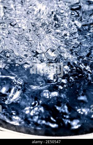 Extreme vertical close-up of water boiling in a pot. Stock Photo