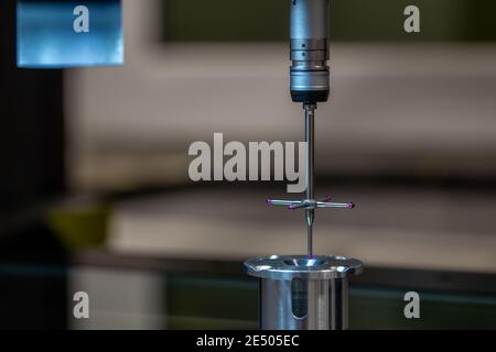 CMM - Coordinate Measuring Machine - contact probe measure aluminium sample part on glass table surface. High precision production metrological contro Stock Photo