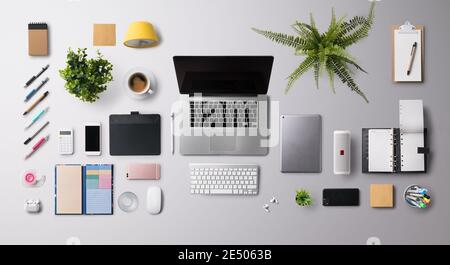 Flat lay top view office desk working space with laptop and supplies on gray background. Stock Photo
