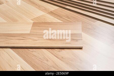 Installing laminated floor, detail on wooden tiles ready to be fit Stock Photo