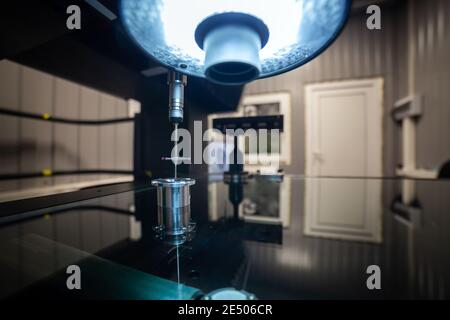 CMM - Coordinate Measuring Machine - contact probe measure aluminium sample part on glass table surface. High precision production metrological contro Stock Photo