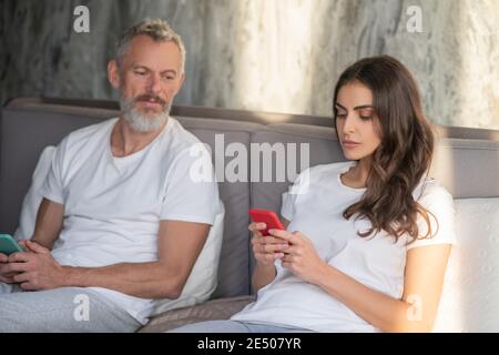 Man looking on her wife using a smartphone Stock Photo