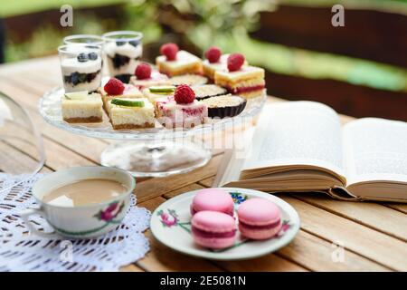 Cup of coffee and desserts on table outdoors on terrace. Stock Photo