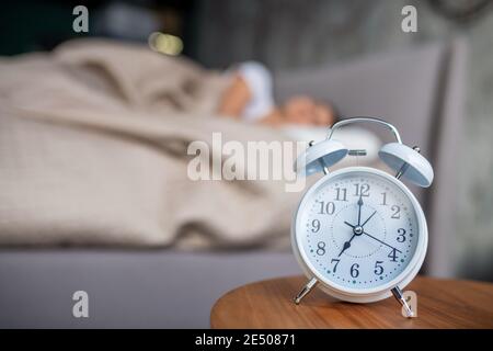 White mechanic alarm cloch standing near the bed Stock Photo