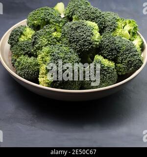 Fresh broccoli in plate isolated on grey background. Top view. Stock Photo