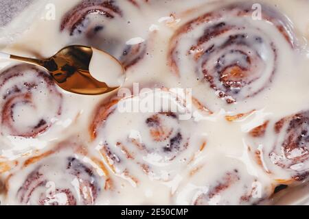 Spoon lying on delicious homemade freshly baked cinnamon rolls Stock Photo