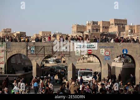 Sanaa, Yemen. 25th Jan, 2021. Houthi supporters attend a rally against the United States over its decision to designate the Houthi rebels movement as a foreign terrorist organization as a poster is displayed on a wall with an Arabic inscription reads 'America is the mother of terrorism'. Credit: Hani Al-Ansi/dpa/Alamy Live News Stock Photo