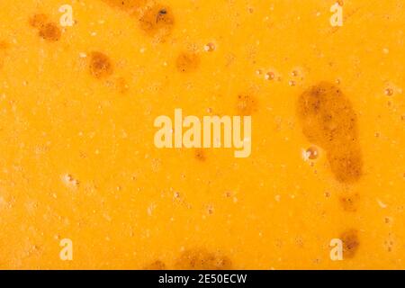 Orange vegetable soup with large fat stains. Close-up. This image may be used as a background. Stock Photo