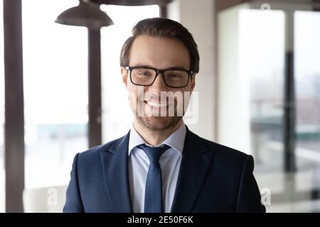 Head shot portrait smiling confident businessman wearing glasses in office Stock Photo