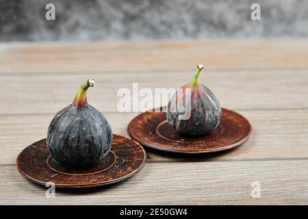 Two plates of figs on a wooden table Stock Photo