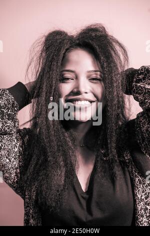 Closeup portrait of a feminine Hispanic woman smiling happily and posing in a studio Stock Photo