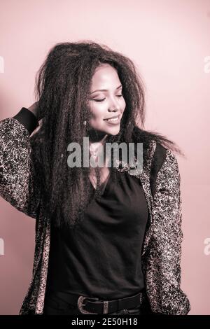 Closeup portrait of a feminine Hispanic woman smiling happily and posing in a studio Stock Photo