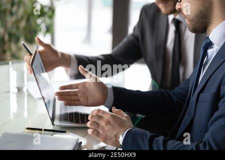 Close up two colleagues working on project together, using laptop Stock Photo