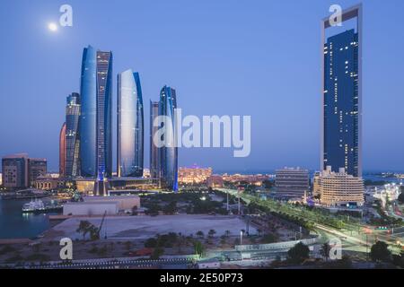 A unique and different perspective of towers and cityscape skyline of Abu Dhabi, UAE at night under moonlight. Stock Photo