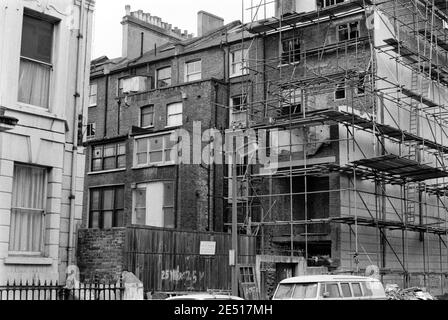 UK, West London, Notting Hill, 1973. Rundown & dilapidated large four-story houses are starting to be restored and redecorated. The back of a house in Colville Terrace (No.42) being redeveloped, viewed from Powis Square. Stock Photo